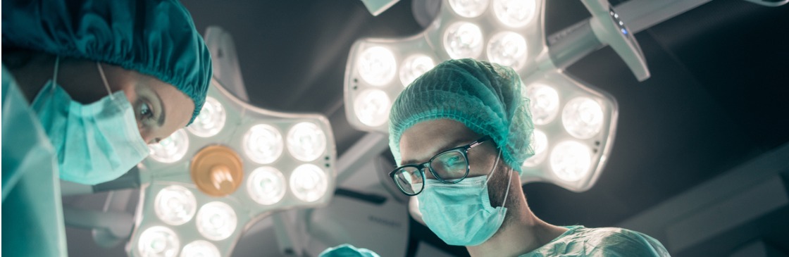 Focused and concentrated young surgeon performing surgical operation in modern operating room